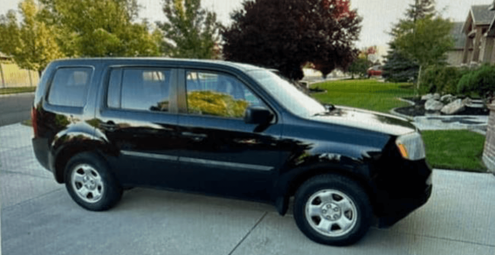 Black Honda Pilot SUV in a residential driveway